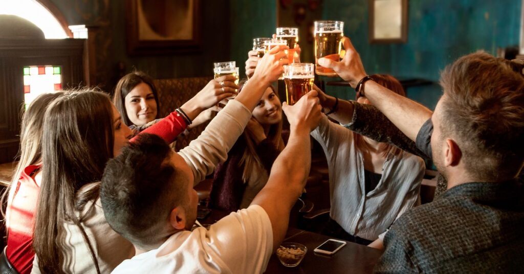 menses proosten met bierpullen in een cafe